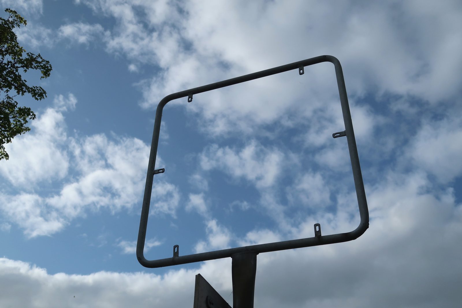 Ein leerer Schilderrahmen vor bewölktem Himmel